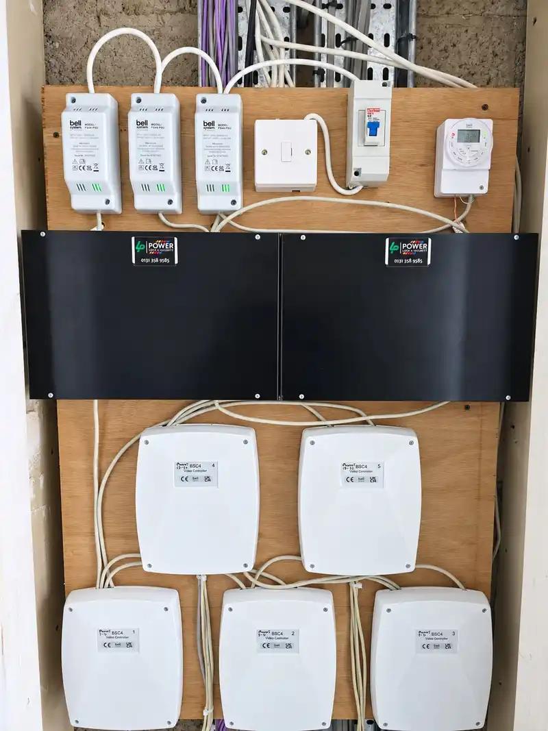 The same backboard finished, with Bell power supplies, an isolator, a timer and branded black covers over the control boards.