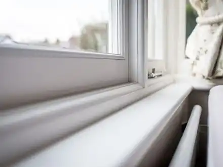 A white uPVC window and sill in a bright room.